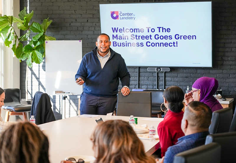 Main Street Goes Green banner image showing a man leading a discussion in a meeting room