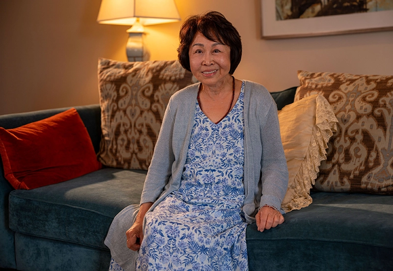 Woman smiling for camera sitting in her living room couch